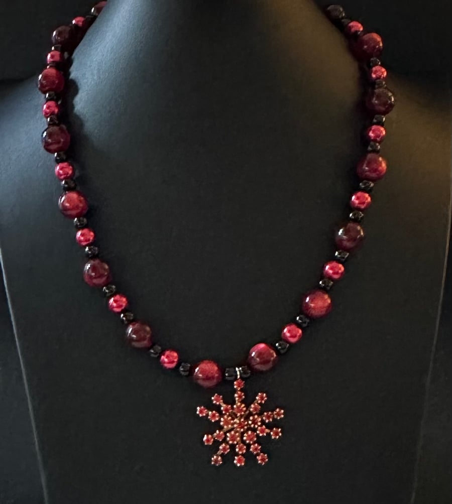 Beaded necklace with a flower charm.