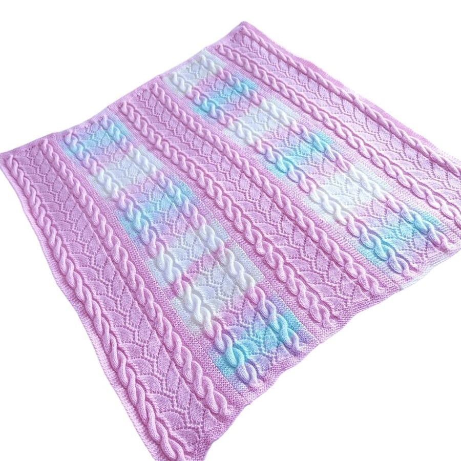 Baby blanket hand knitted in pink and pastel stripes with lace and cable design 