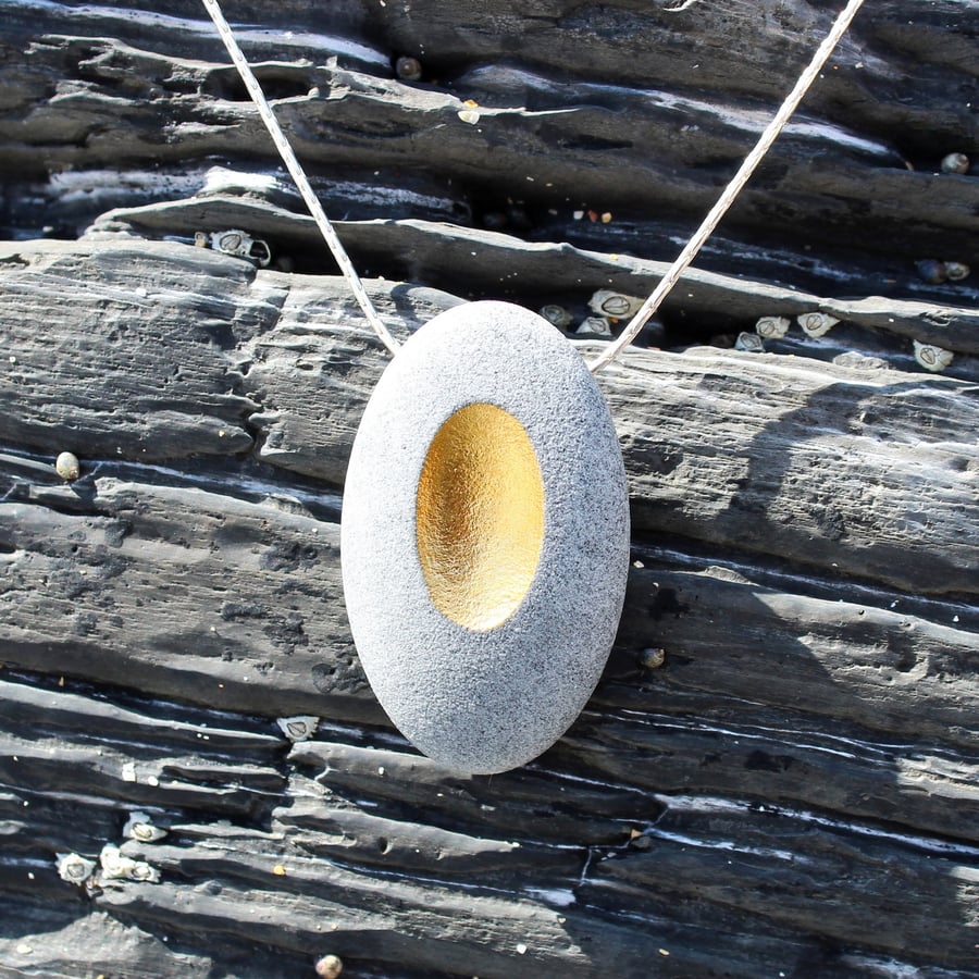 Pebble pendant necklace with a golden identation desgined by John Field jeweller