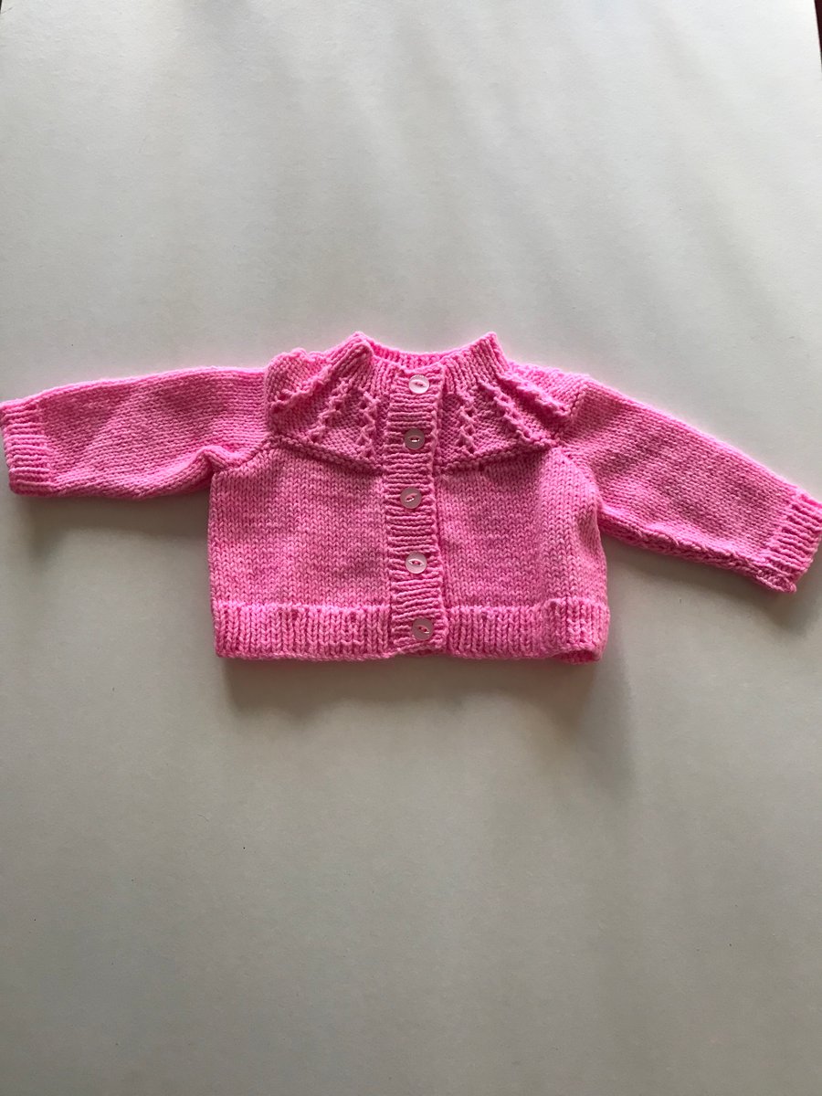 Bright pink hand knitted cardigan with patterned yoke