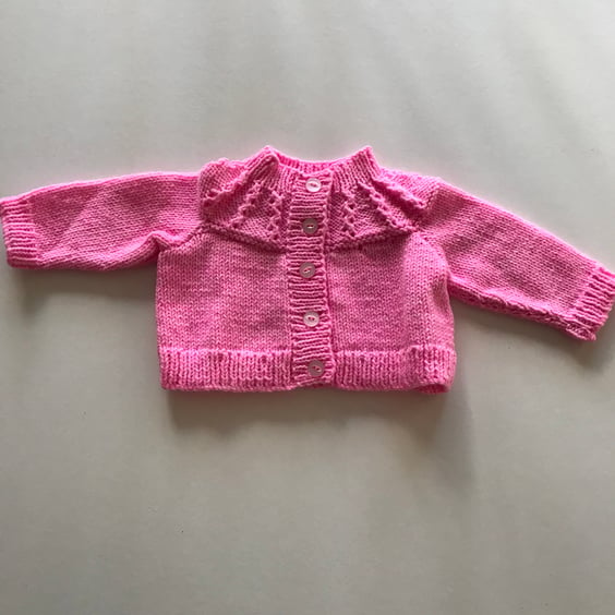Bright pink hand knitted cardigan with patterned yoke