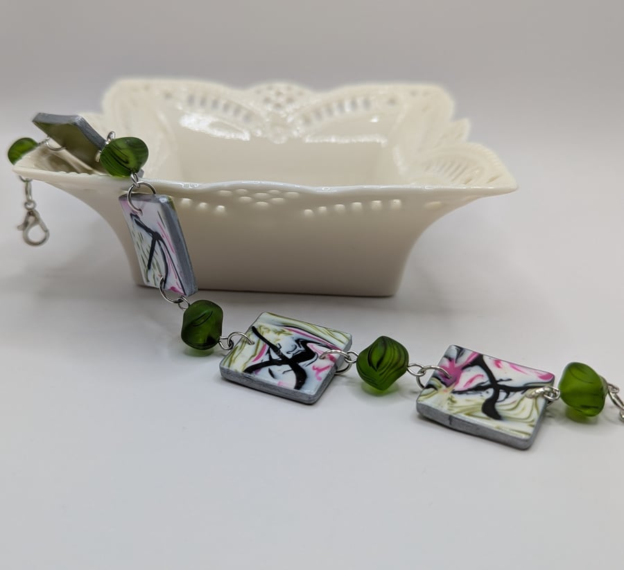 Abstract marbled pattered bracelet, in green and pink.