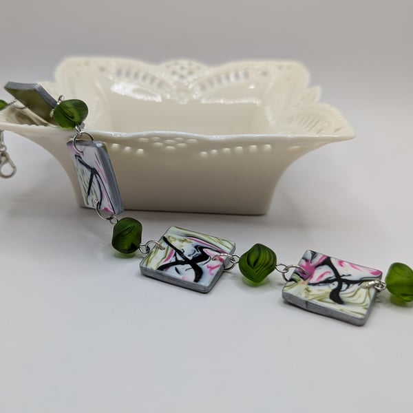 Abstract marbled pattered bracelet, in green and pink.
