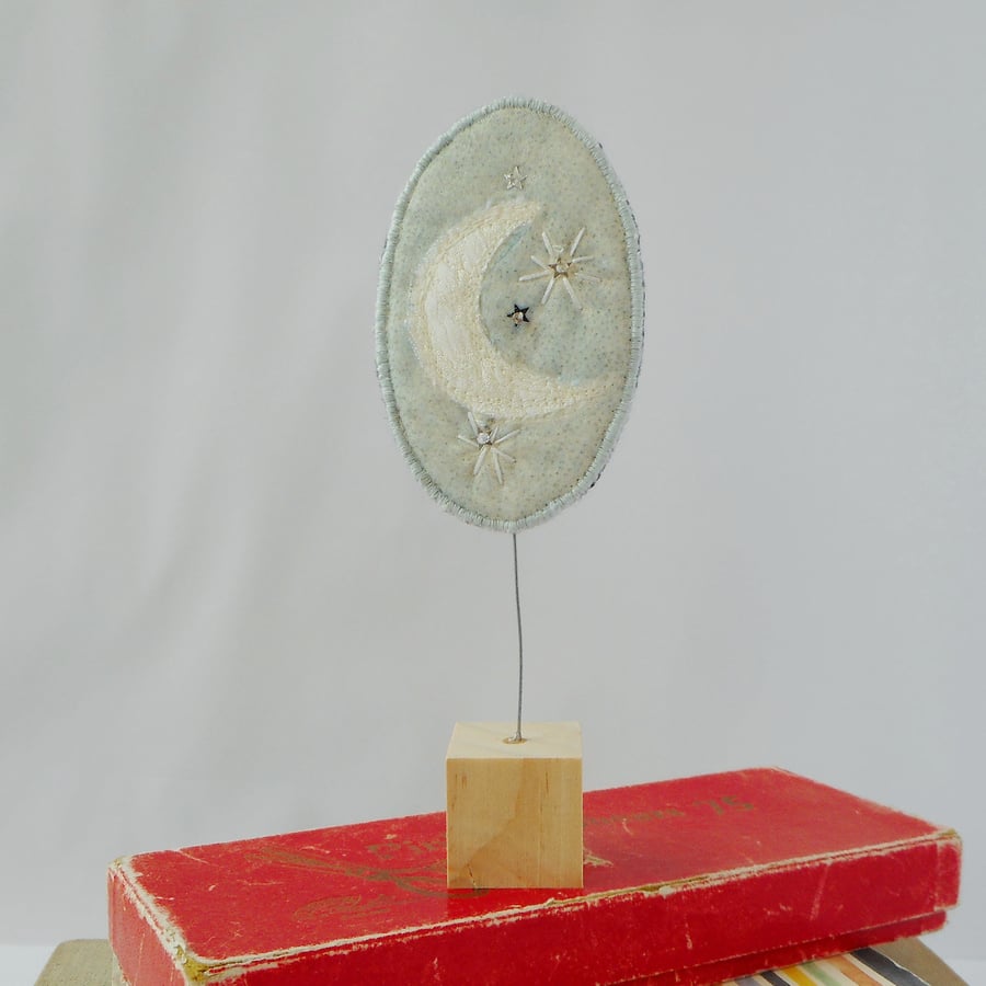 Embroidered Moonbeam fabric ornament on wooden block