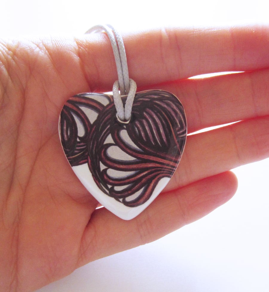Filigree Artwork Design on Heart Shaped Ceramic Pendant on Grey Cord