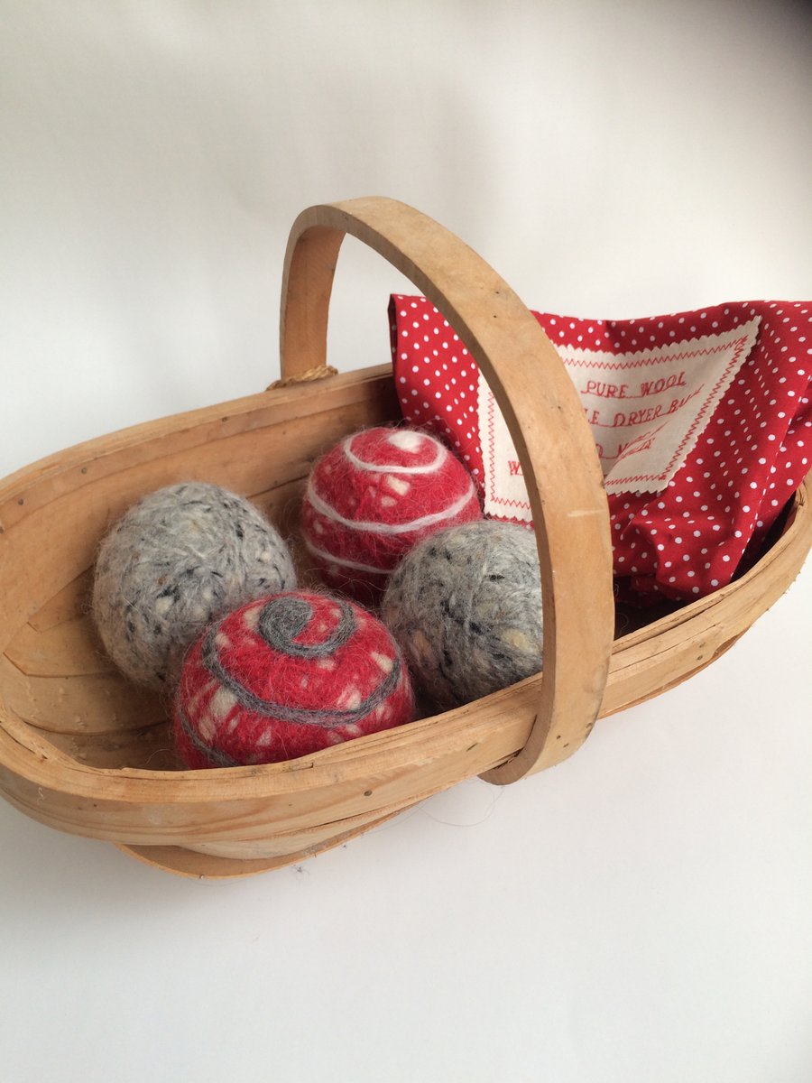 Four wool tumble dryer balls in  reds and greys. Energy saving and plastic free.