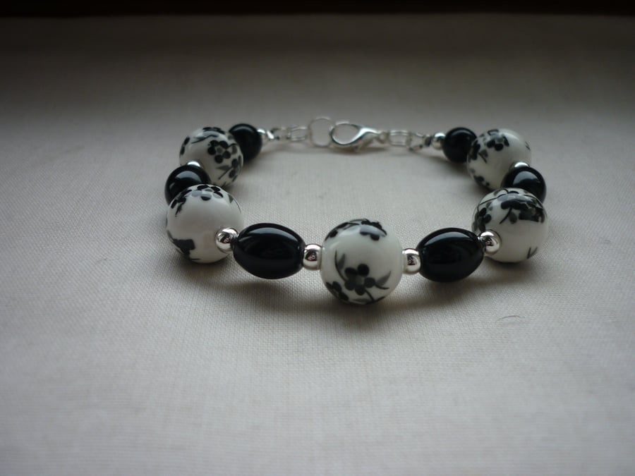 BLACK AND WHITE FLORAL PORCELAIN BEAD BRACELET. 