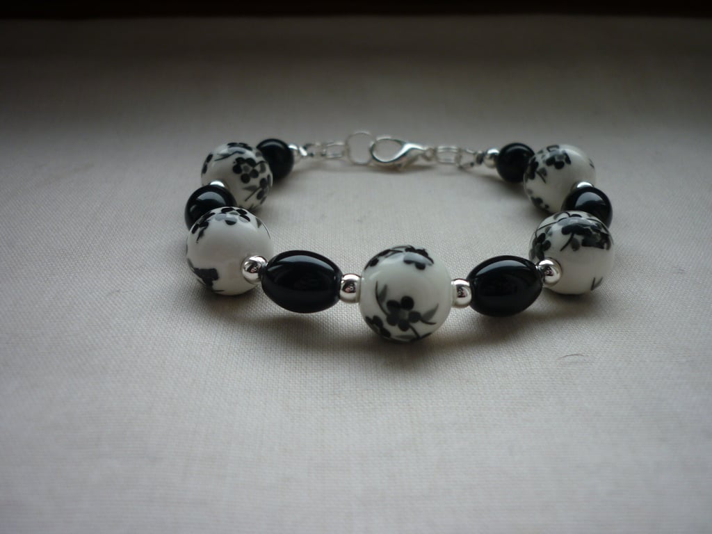 BLACK AND WHITE FLORAL PORCELAIN BEAD BRACELET. 