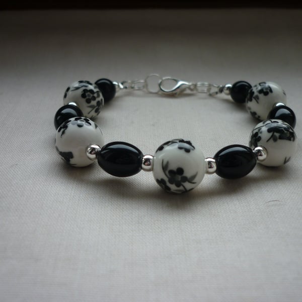 BLACK AND WHITE FLORAL PORCELAIN BEAD BRACELET. 