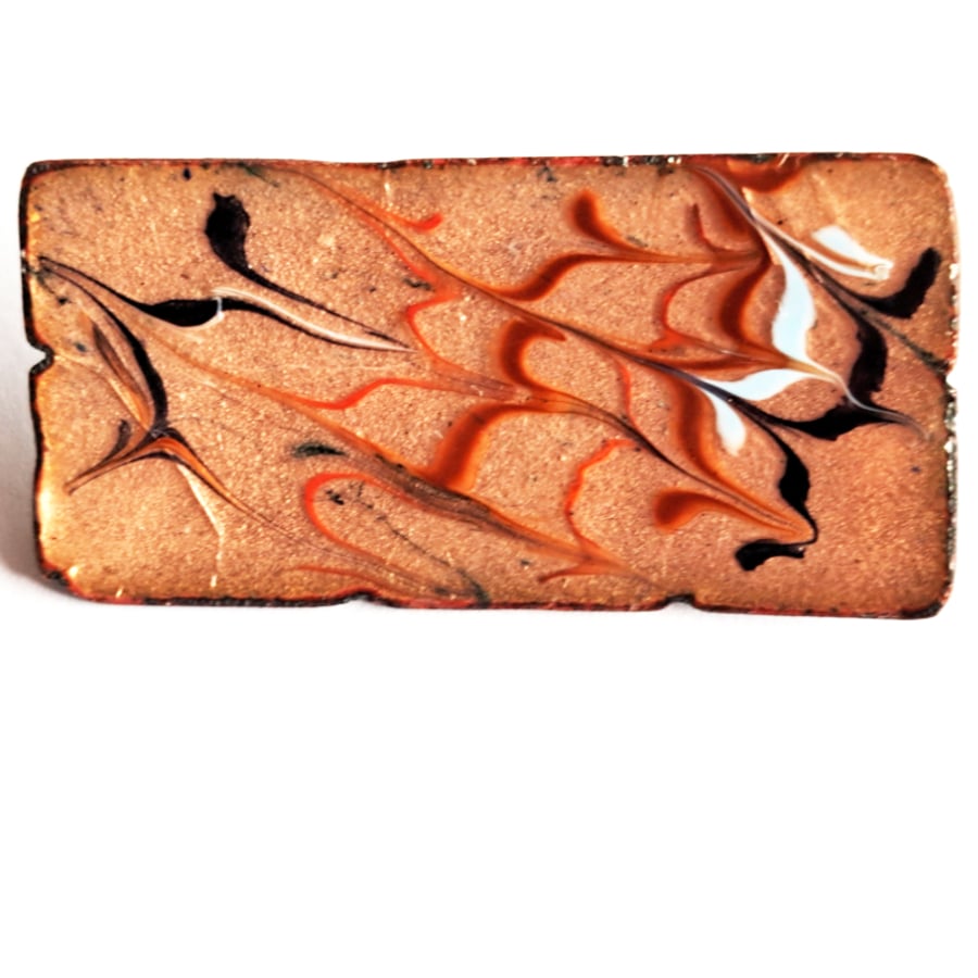 brooch - rectangular: scrolled red, brown, pale blue and black over clear enamel