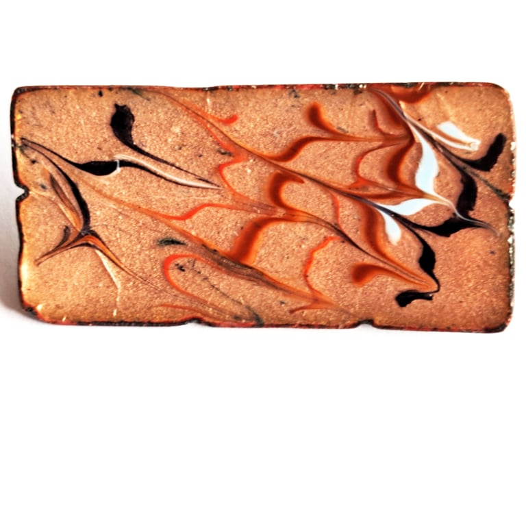 brooch - rectangular: scrolled red, brown, pale blue and black over clear enamel