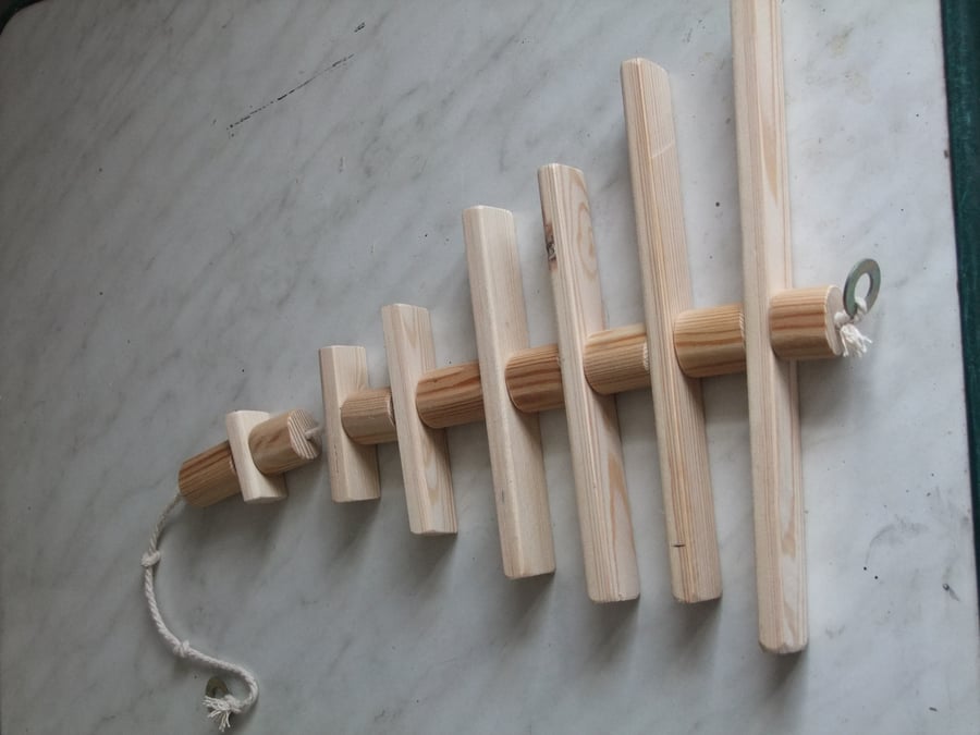 Toy for a caged bird, made from different sized round pieces of smooth pine.