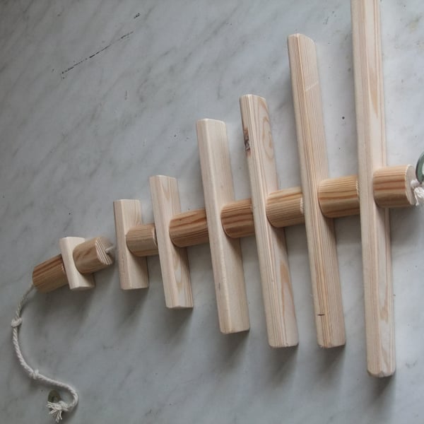 Toy for a caged bird, made from different sized round pieces of smooth pine.