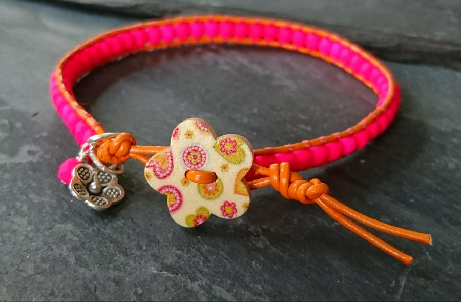 Bright orange leather and neon pink bracelet with wooden flower button