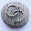 Sterling silver stud hoop earrings made from twisted square wire.