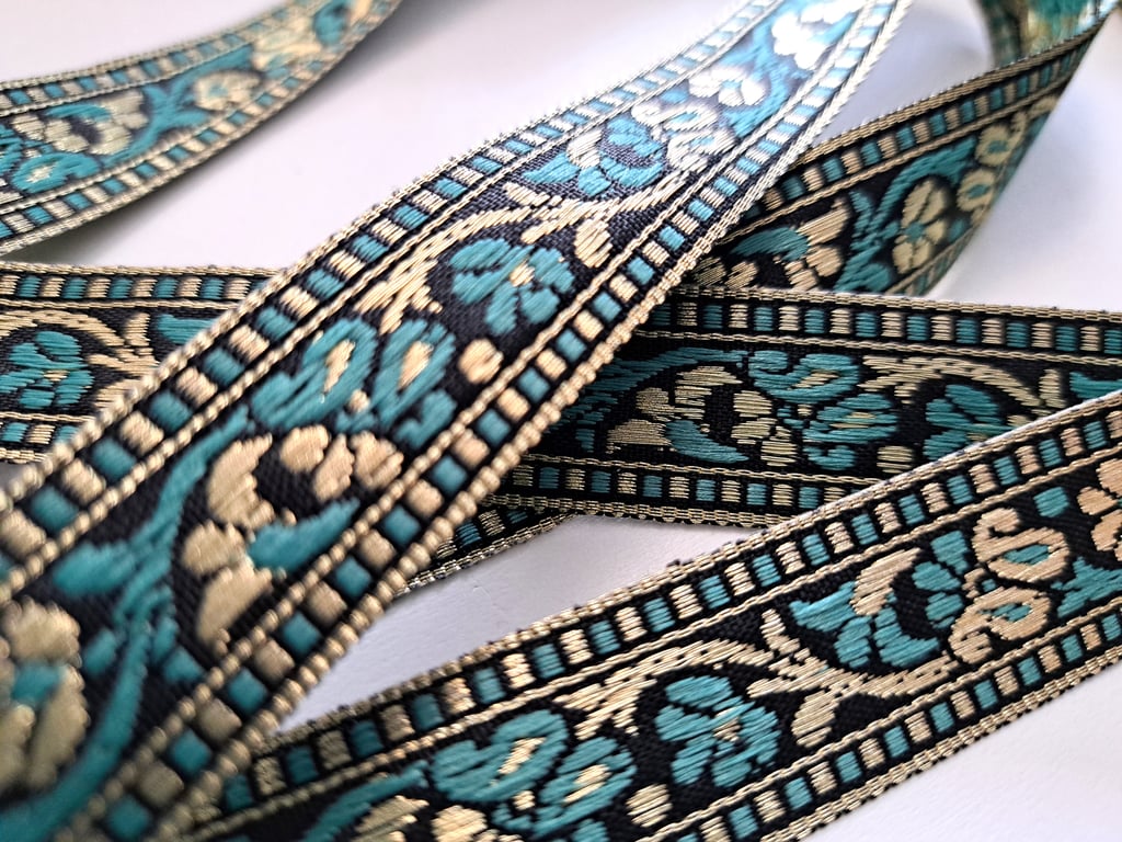 1.7 metres of light teal, black and gold ribbon, 22mm wide