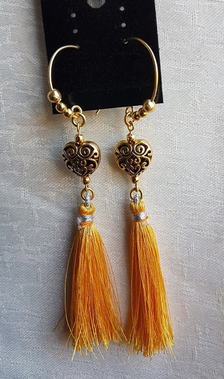 Orange Tassel Earrings with Filigree heart beads.
