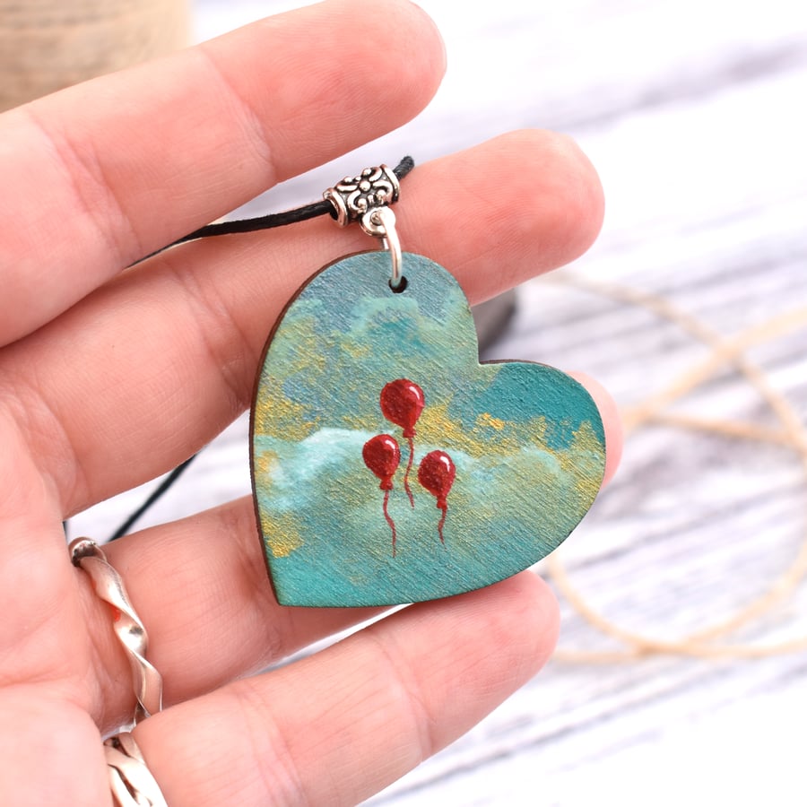 Up, up and away! Wooden heart pendant with red balloons.