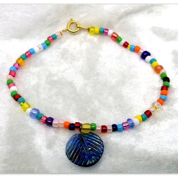 Seed bead bracelet mixed colour glass beads with a blue glass charm.