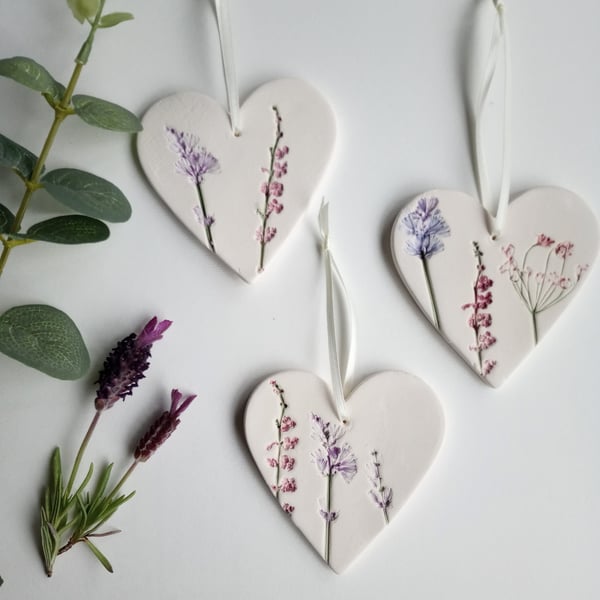 Set of 3 ceramic heart hangings with a botanical print.