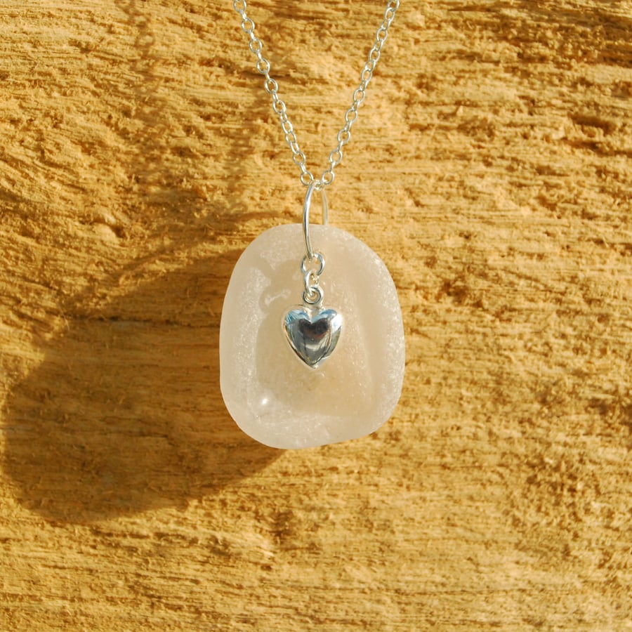 White sea glass pendant with silver heart charm