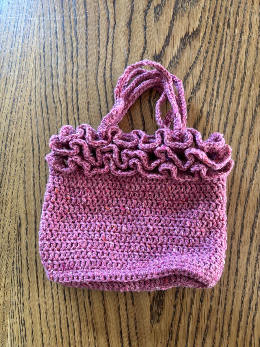 Small frilly woollen crochet handbag in a raspberry red