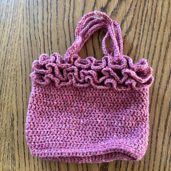 Small frilly woollen crochet handbag in a raspberry red