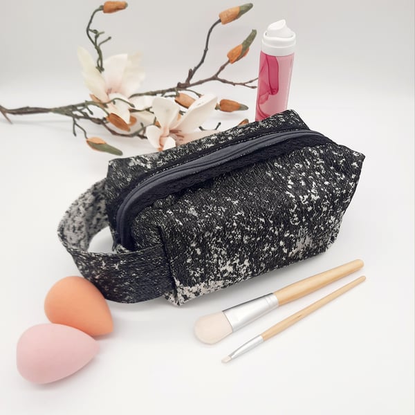 Boxed makeup bag in black and silver with handle. 