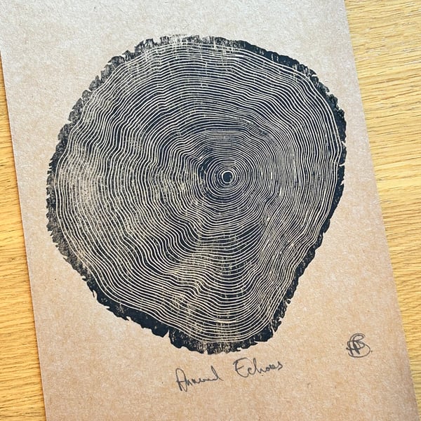 Annual Echoes - Handprinted Tree Rings linocut print. A4 black on brown card.