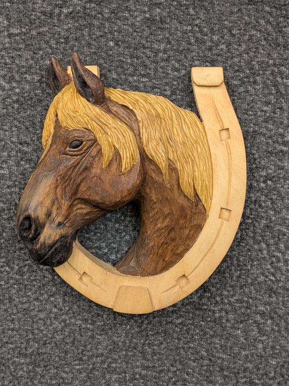 Wooden hand carved horse head in horse shoe 