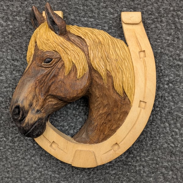 Wooden hand carved horse head in horse shoe 