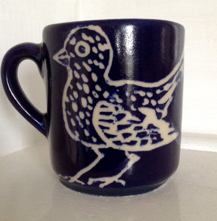 Mug with bird design in midnight blue,  holding half pint. 
