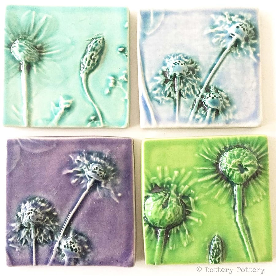 Set of four ceramic tiles with flower imprints and bright glazes purples, blues