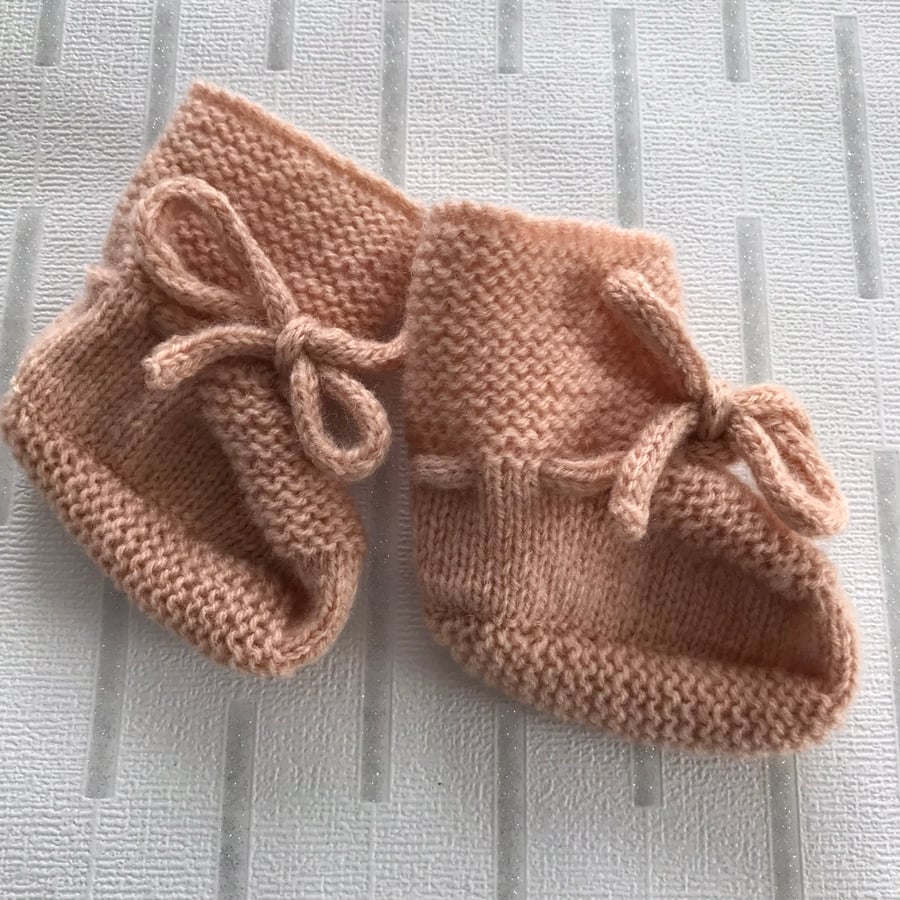 Hand knitted peach coloured bootees