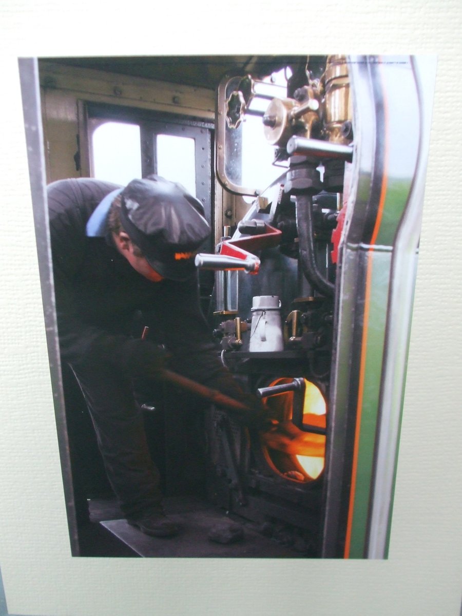 Photographic greetings card of a railway man working hard in the cab.