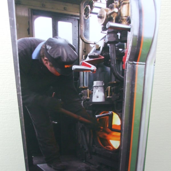 Photographic greetings card of a railway man working hard in the cab.