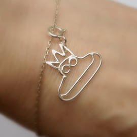 A tiny frog charm made in sterling silver from a childs drawing. 