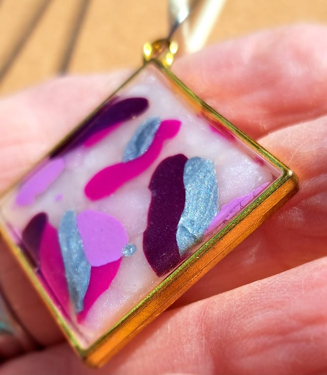 Rope necklace with a polymer clay filled bezel. Pink, silver, burgundy, purple.