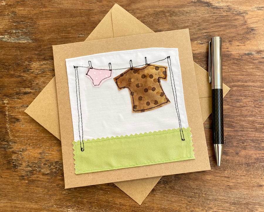Up-cycled T-shirt and pants hanging on a washing line embroidered card. 