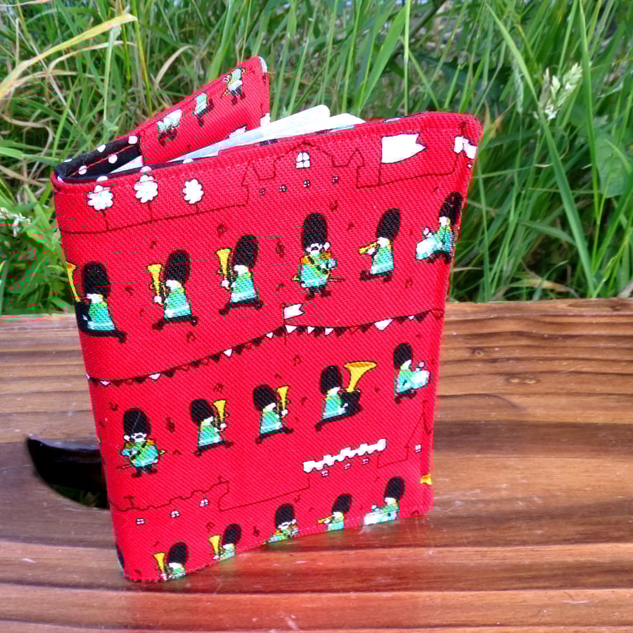 A fabric passport cover with a whimsical, marching soldiers design.