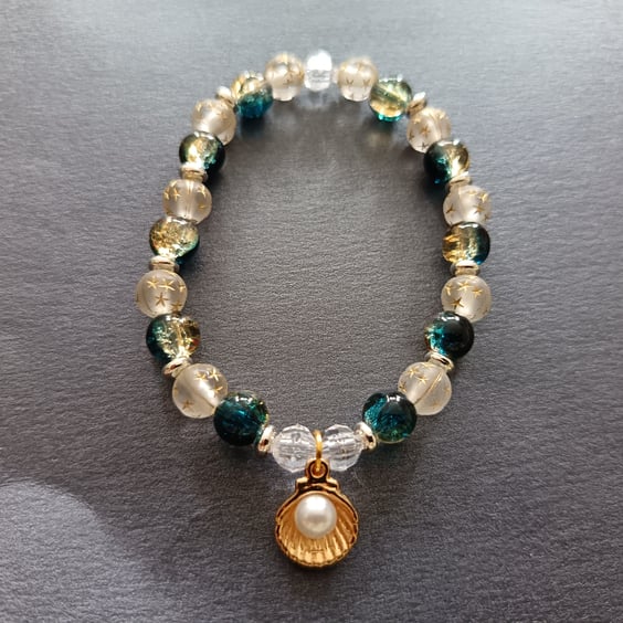 Elasticated bracelet with nautical themed beads and gold shell charm