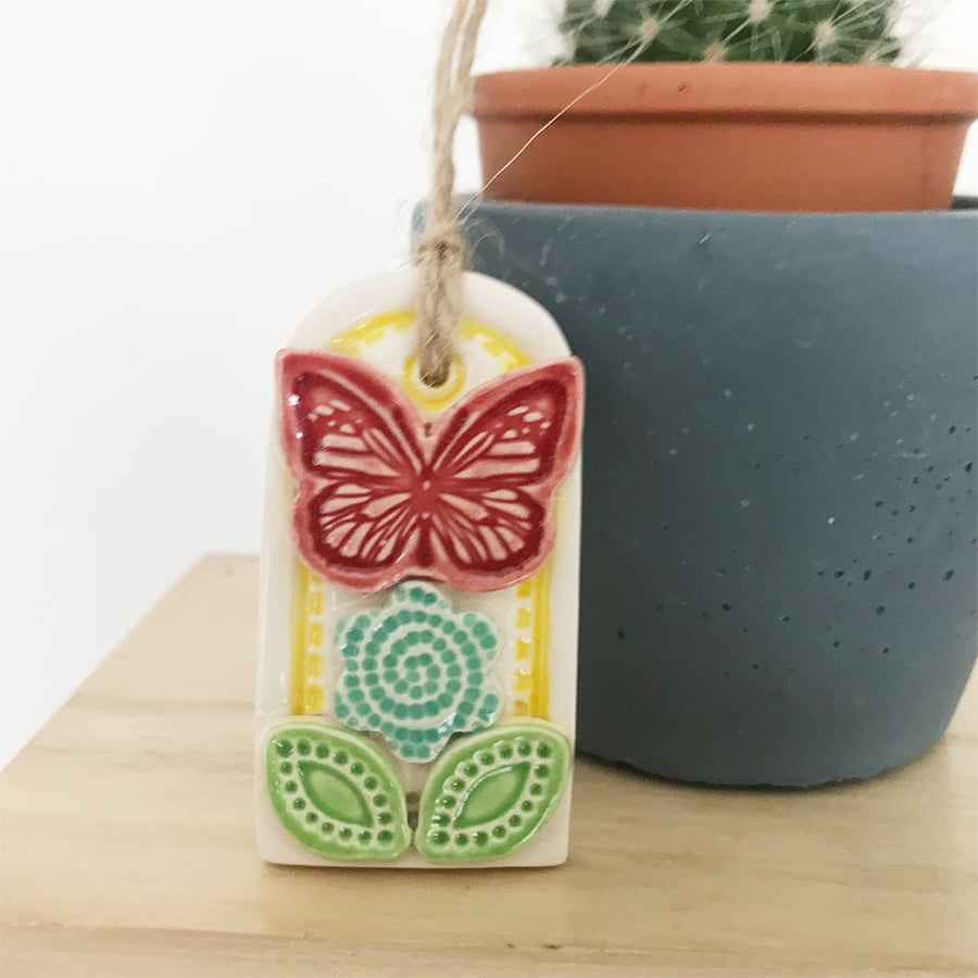 Small decorative pottery gift tag with flower and butterfly hanging decoration