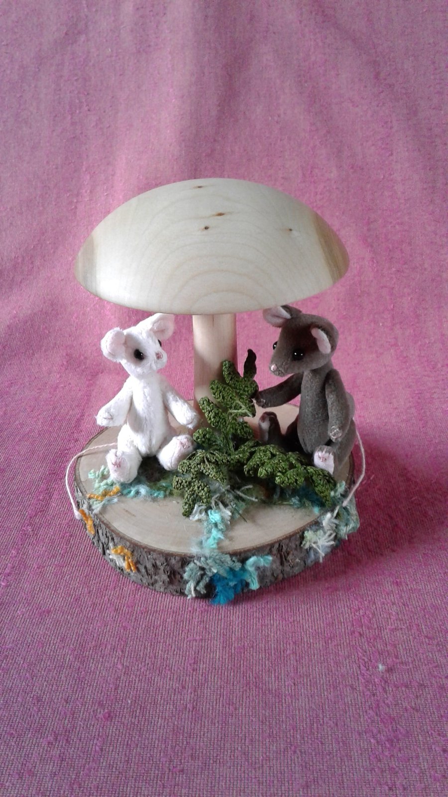 2 miniature mice, Button and Chestnut, relaxing under a mushroom