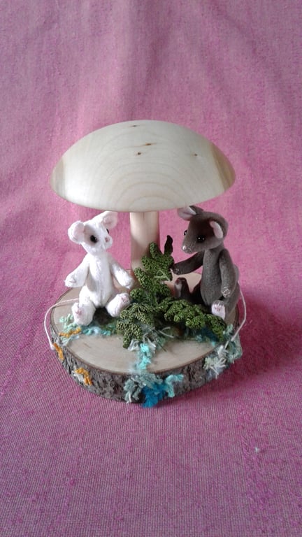 2 miniature mice, Button and Chestnut, relaxing under a mushroom