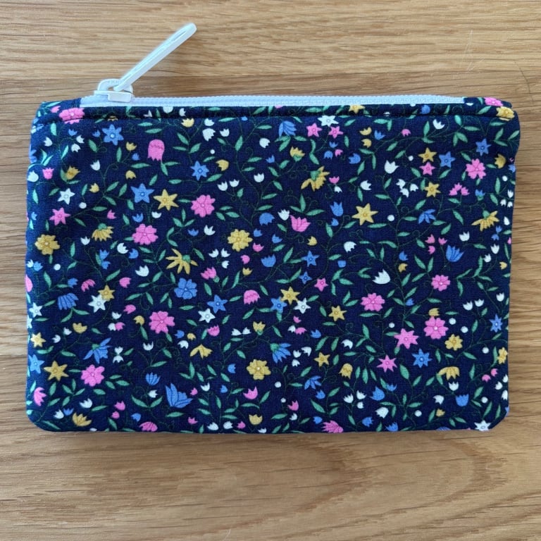 Small zipped fabric coin purse, pouch, in navy, with bright floral print.