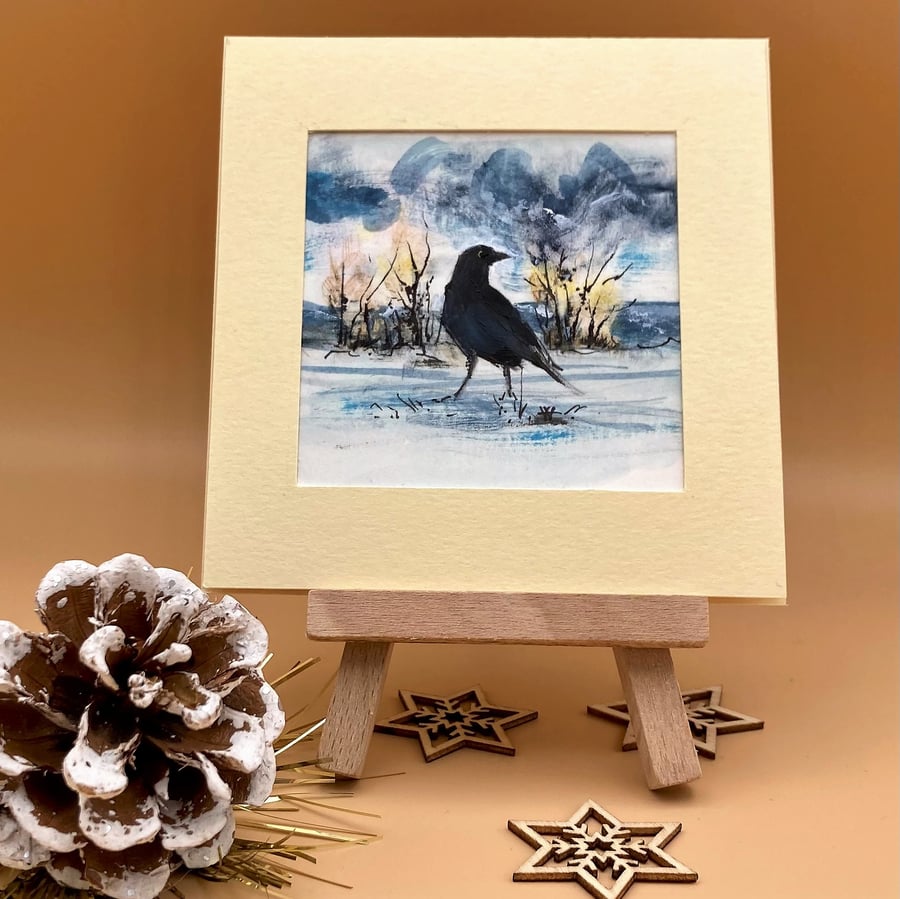 Small original painting of a black crow bird in a winter landscape, acrylic