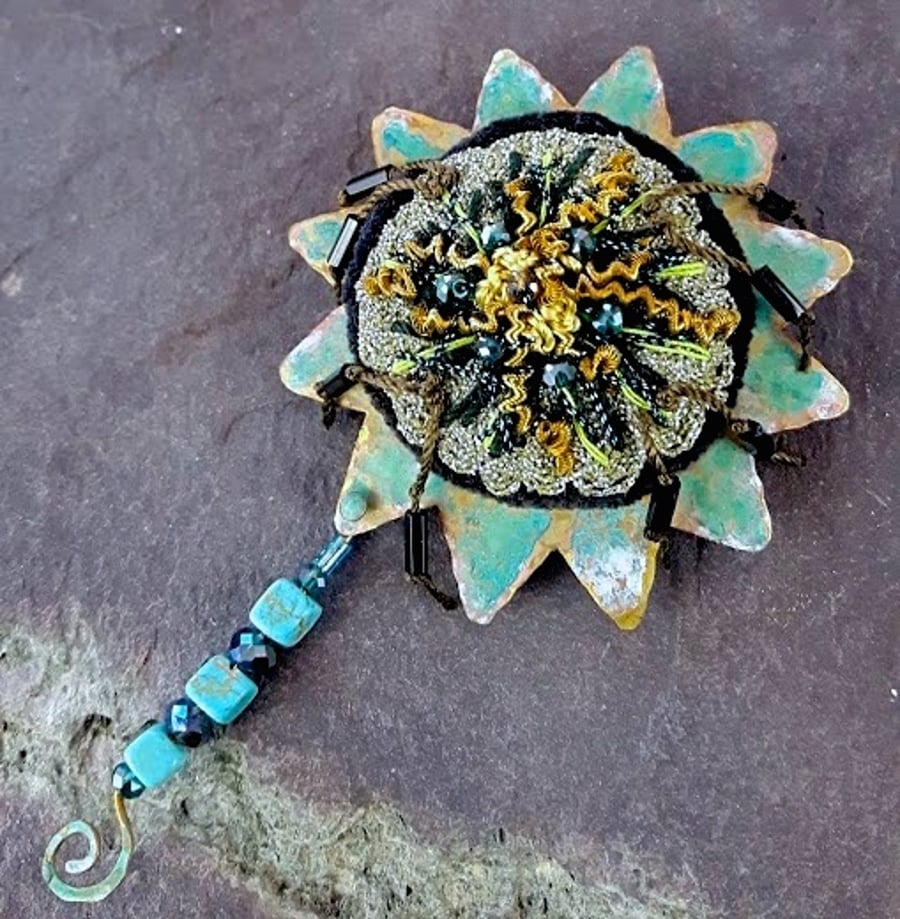 Ornate embroidered brooch.