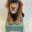 Handcrafted needle felted lion with removable party hat on a wooden box