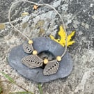 Beige autumn leave necklace with silver bead detail