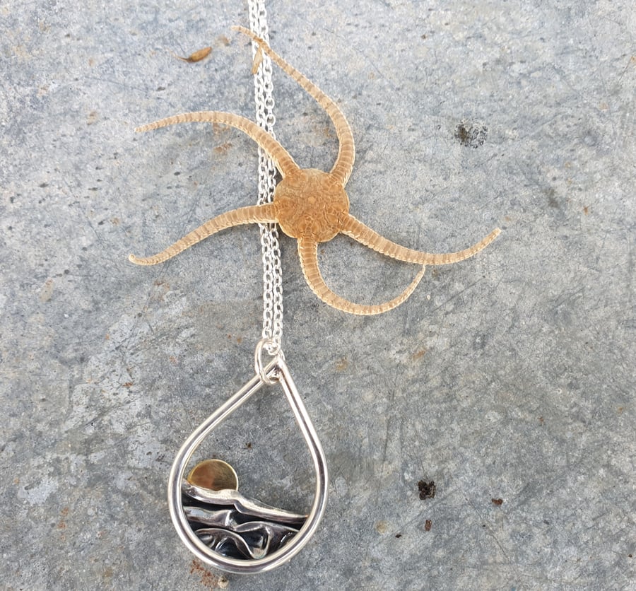 Silver sun rising over sea pendant